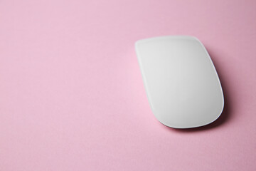 One wireless mouse on pink background. Space for text