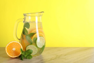 Sticker - Freshly made lemonade with mint in jug on wooden table against yellow background, space for text