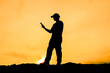 © STOCK PHOTO 4 U - Silhouette of a Man Using a Smartphone at Sunset with a Golden Sky Background
