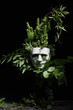© New Africa - Theatrical performance. Plastic mask and floral decor on table against black background