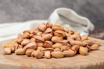 Wall Mural - Pile of pistachios on wooden background. Close up