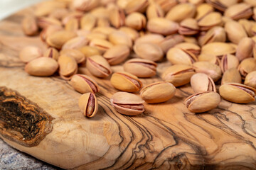 Wall Mural - Pile of pistachios on wooden background. Pistacia vera