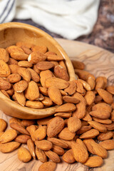 Wall Mural - Almonds on wood background. Roasted almonds in a bowl. Close up