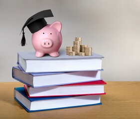 Wall Mural - Graduation hat on piggy bank with coins