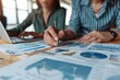 © Maxim Borbut - An office background with graphs and statistics shows professionals analyzing financial data.