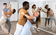 © JackF - Man and woman in pairs learning to dance waltz in modern studio