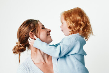 Mother and daughter bonding moment in a white studio, love, family, happiness, childhood, embrace, care, affection, togetherness