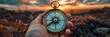 © mattegg - Hand Holding Compass Against Sunset Sky