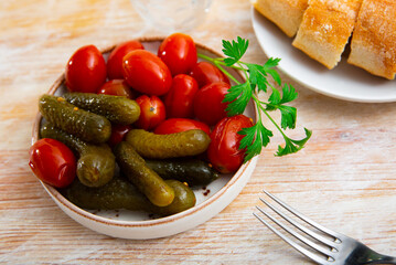 Wall Mural - Delicious pickled cucumbers with tomatoes, decorated with a sprig of fresh greenery on a plate