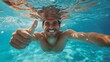 © Joyce - Underwater portrait of happy male with thumbs up gesture in swimming pool.