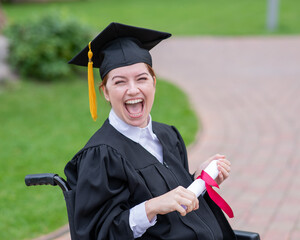 Happy caucasian woman in a wheelchair holding her diploma outdoors.