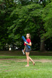 © Tirso Lecointere - Side view of beautiful happy latin woman barefoot holding yoga mat and water bottle to start exercising in the outdoors public park