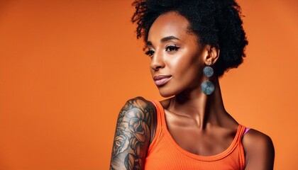 Wall Mural - Black young woman with arm tattoos isolated on orange background afro hair cool vibe