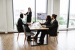 © sofiko14 - Business team in formal attire engaging in presentation with charts and graphs in modern office setting. Presenter pointing at screen with statistical data. Group discussion and teamwork illustrated.