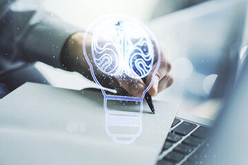 Poster - Creative light bulb with human brain hologram and hand writing in notepad on background with laptop, artificial Intelligence and neural networks concept. Multiexposure
