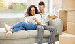 © Anela Ramba/peopleimages.com - Tablet, boxes and couple on sofa in new home for property investment and mortgage approval. Happy, moving and people with digital technology for planning rental apartment layout in living room.