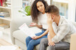 © peopleimages.com - Documents, sofa and couple with stress in home for eviction notice, financial crisis and issue. Frustrated, man and woman with paperwork in house for mortgage investment, info and payment problem