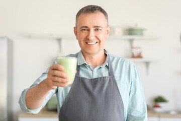 Poster - Mature man with glass of fresh vegetable smoothie in kitchen, closeup