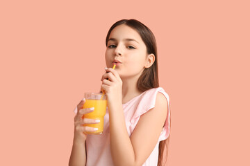 Poster - Little girl drinking orange juice on pink background