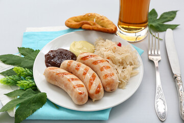 Plate with tasty Bavarian sausages, sauerkraut and sauces on grey background. Oktoberfest celebration