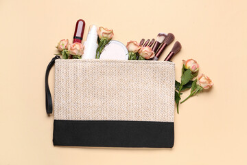 Wall Mural - Cosmetic bag with makeup products and beautiful rose flowers on beige background