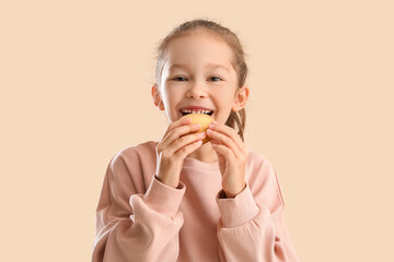 Poster - Cute little girl with cookie on beige background