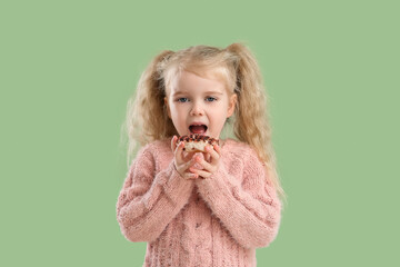 Wall Mural - Cute little girl with donut on green background