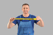 © Pixel-Shot - Male construction worker with measuring tape on grey background