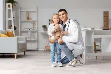 Canvas Print - Male pediatrician and little girl with teddy bear in clinic