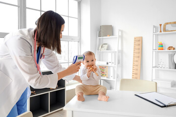 Sticker - Female pediatrician measuring temperature of little baby in clinic