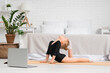 © Pixel-Shot - Cute little girl doing gymnastics with laptop at home