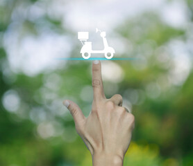 Poster - Hand pressing motorcycle flat icon over blur green tree in park, Business delivery service concept