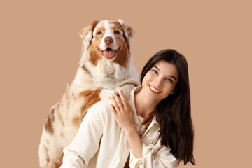 Sticker - Young woman with Australian Shepherd dog on beige background