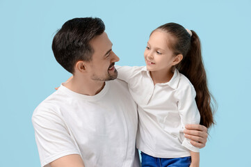 Wall Mural - Father and his little daughter on blue background. Father's Day celebration
