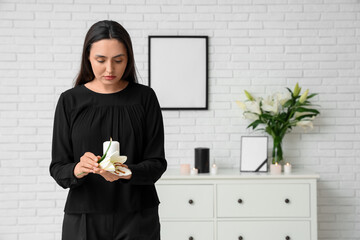 Wall Mural - Young woman with funeral lily flower and burning candle in room