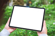 © Farknot Architect - Mockup image of a woman holding digital tablet with blank white desktop screen in the outdoors