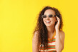 © Pixel-Shot - Happy young African-American woman in sunglasses on yellow background