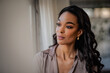 © sepy - Close-up portrait of a young african-american woman standing at the window and looking away