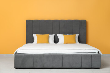 Wall Mural - New orthopedic mattress with blanket on stylish bed near yellow wall in room