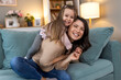 © Graphicroyalty - Young family, hug and portrait of child with mother, mom or mama bond, relax and enjoy quality time together. Love, happy family and woman with kid girl smile, care or lounge on home living room sofa