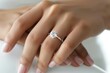 © reels - Close-up of a woman's hand with an elegant diamond engagement ring, showcasing the beautifully manicured nails on a soft-focus background.