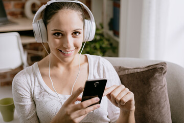 Wall Mural - Girl connecting with her phone and listening to music