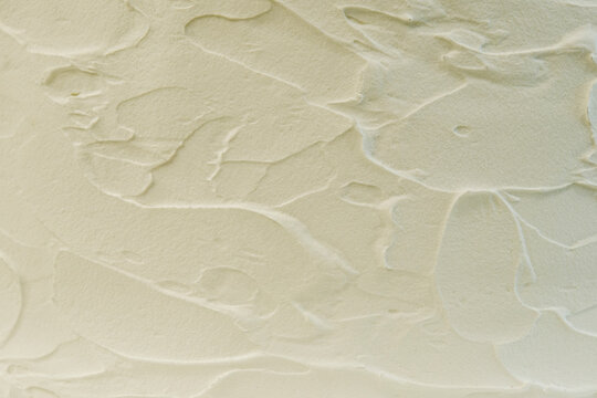荒く塗りこまれたクリームのような素材を塗られた壁の背景テクスチャー　