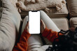 © john - woman holding iphone laying on sofa with white screen mockup and pillow, in the style of use of fabric, clear edge definition