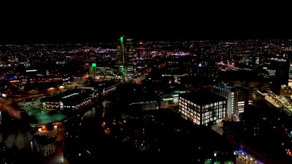Wall Mural - Night time aerial footage of the town of Leeds City Centre taken at night with a drone showing the West Yorkshire city centre all lit up with lights from roads and apartments near the Train Station