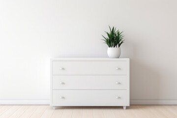 A white dresser with three drawers sits in a room with a white wall