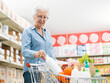 © StockPhotoPro - Senior woman putting goods in the shopping cart