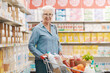© StockPhotoPro - Confident senior woman doing grocery shopping at the supermarket