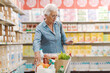 © StockPhotoPro - Senior woman checking her grocery list at the supermarket