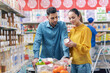 © StockPhotoPro - Happy couple doing grocery shopping at the supermarket